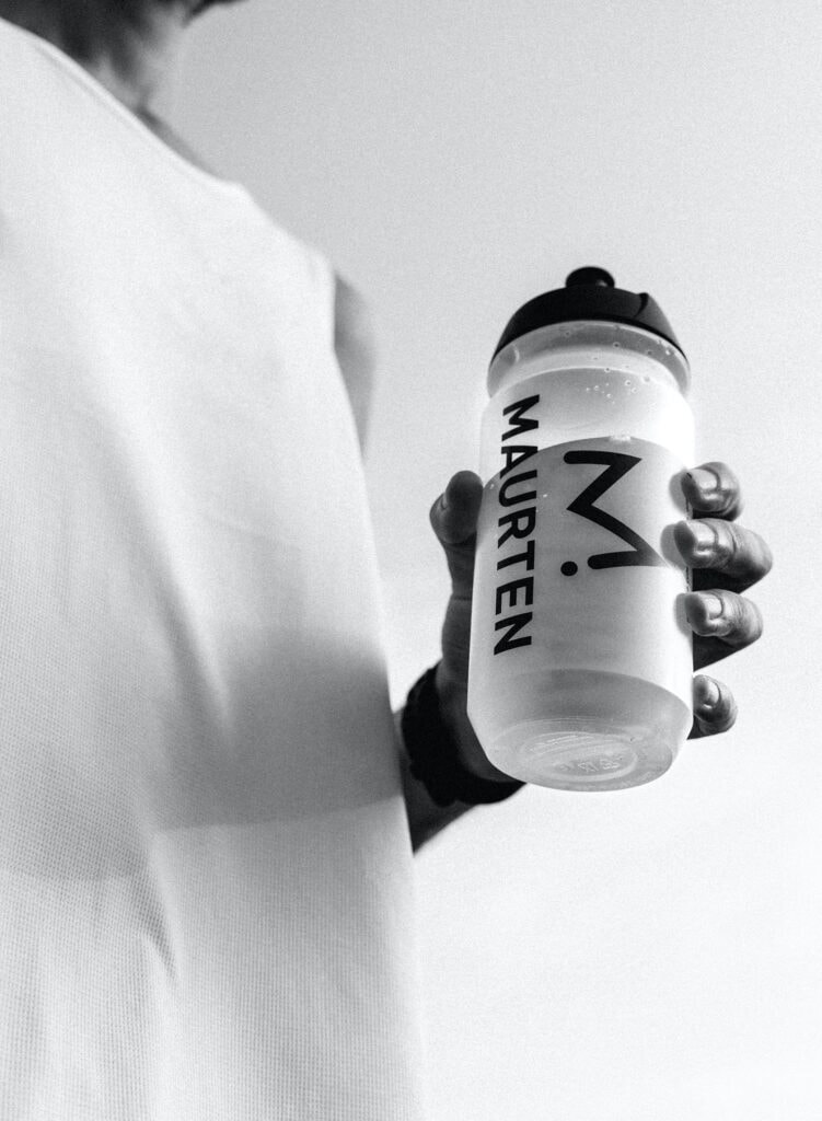 Atleta sosteniendo la botella Maurten 500 ml en blanco y negro